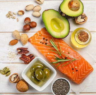 healthy-fats-foods-energy-hormone-balance Healthy fats like avocado, salmon, and nuts that support hormone balance and energy