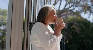 daily-habits-women-over-40-peaceful-routine Middle-aged woman enjoying a peaceful daily routine at home with soft natural light